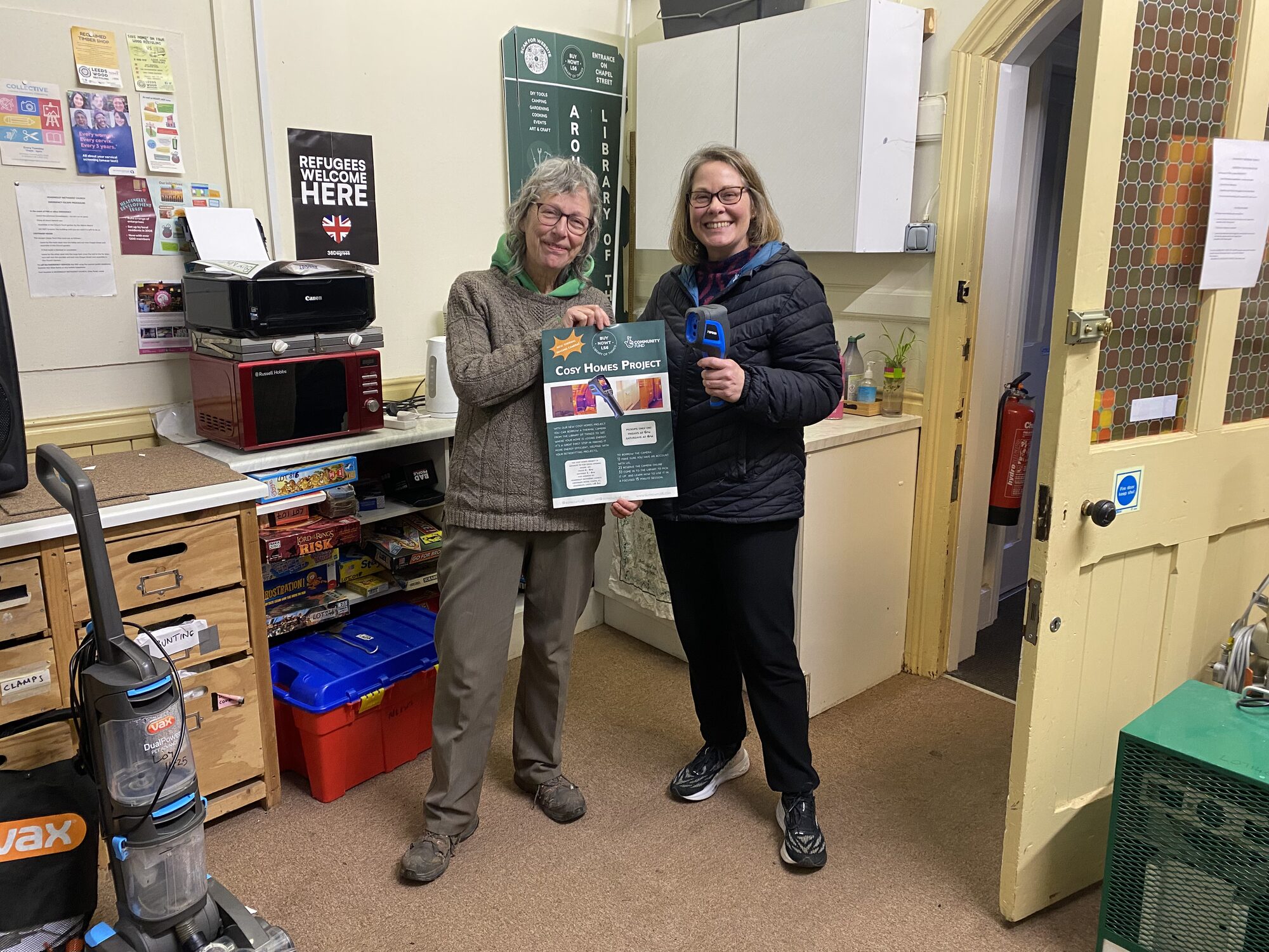 Volunteers with the Cosy Homes Project poster and thermal imaging camera